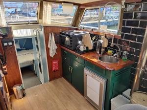 a kitchen with green cabinets and a sink in an rv at Downtown Boat-Apartment in Gothenburg