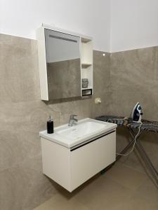 a bathroom with a white sink and a mirror at Marina Oasis Apartments in Vlorë +40 photos