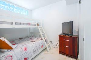 a bedroom with a bunk bed and a television on a dresser at Ocean Breeze Retreat in Miami Beach in Miami Beach