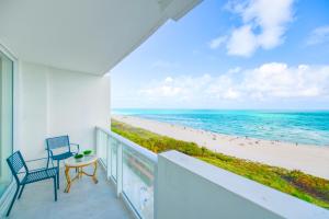 a balcony with a table and chairs and the beach at Ocean Breeze Retreat in Miami Beach in Miami Beach