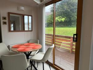 a dining room with a table and chairs and a balcony at Cosy Caravan by the sea in Cairnryan