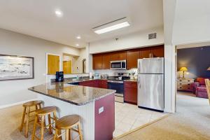 a kitchen with a refrigerator and some bar stools at Kestrels Unit #16 in Morses Mill