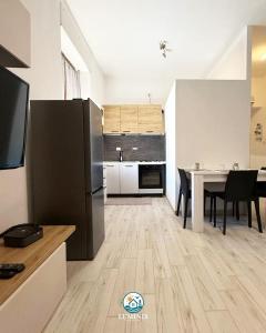 a kitchen with a table and a black refrigerator at Luminis Holiday Home in Porto Torres