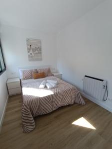 Un dormitorio con una cama con dos almohadas encima. en Apartamentos Gabín, en Montederramo