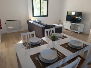 a dining room with a table with plates and wine glasses at Apartamentos Gabín in Montederramo