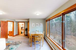 a dining room with a table and some windows at Edson Hill Getaway #4 in Stowe Fork