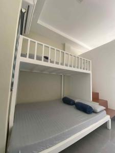 un letto a castello bianco con due cuscini blu sopra di three x apartelle a Città di Tagbilaran