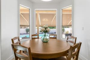 un tavolo da pranzo con un vaso di fiori sopra di 4 King Size Beds - Hot Tub & Pool ad Avondale