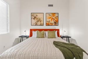 un letto con testiera arancione e tre quadri sul muro di 4 King Size Beds - Hot Tub & Pool ad Avondale Altre 11 foto