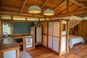 a room with a kitchen and a bed in a cabin at Finca Aveterra, Luxurious Riverside Retreat in Mindo