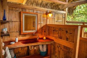 a bathroom with a sink and a mirror at Finca Aveterra, Luxurious Riverside Retreat in Mindo