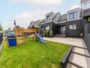 a yard with a playground in front of a house at Comfortable holiday homes close to the beach in Grzybowo