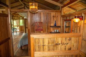 a room with a wooden wall in a cabin at Finca Aveterra, Luxurious Riverside Retreat in Mindo