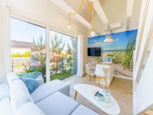 a living room with a white couch and a table at House in Grzybowo near the beach, private sauna in Grzybowo