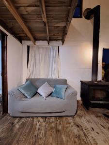 a bed with three pillows on it in a room at La casita in Barra de Valizas