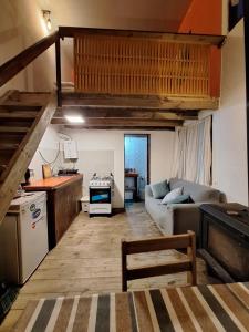 a living room with a couch and a kitchen at La casita in Barra de Valizas