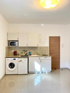 a kitchen with a washer and dryer in a room at Cozy apartment near the beach in Haifa