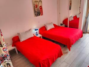 two beds in a room with red sheets at Jupiter Apartments Sea View in Benalmádena +14 photos