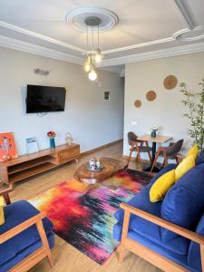 a living room with a blue couch and a colorful rug at Akhard Haus in Buea