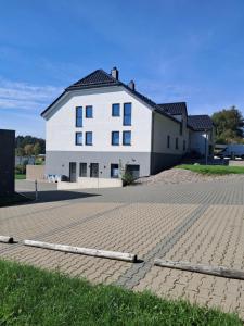 a large white house with a brick driveway at B&B V.K. PGmbH in Saint-Vith