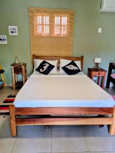 un letto in una stanza con una struttura in legno di Apartamento Perequê Lá da Ilha a Ilhabela