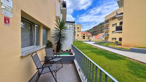 twee stoelen op het balkon van een gebouw bij Dragoeiro Duplex by Sam Houses in Ribeira Brava