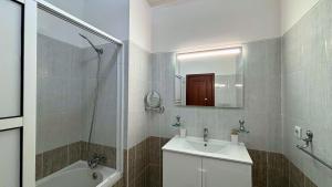 een witte badkamer met een wastafel en een douche bij Dragoeiro Duplex by Sam Houses in Ribeira Brava +11 foto's