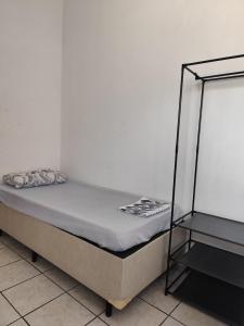 サンパウロにあるWR7 hostel SP EXPO a 5 min da expoの白い壁の隣の部屋にあるベッド