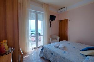 una camera da letto con un letto e una grande finestra di Hotel Barca D'Oro a Bellaria-Igea Marina