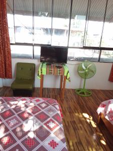 a room with a bed and a table and a window at Puerto Maldonado Hostel in Puerto Maldonado +7 photos