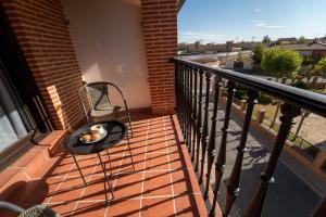 Un balcón con un banco con un plato de comida encima. en Olmedo Hostal Plaza, en Olmedo