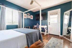 a bedroom with blue walls and a bed with a table at Cozy Room with Hot Tub, Pool, Sauna & Gym Near Beach in Oceanside +9 photos