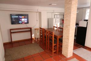 a kitchen with a wooden table and a refrigerator at Alojamento no Centro de Concórdia acomodação inteira você terá todo o espaço só para o seu grupo de até 6 pessoas e com estacionamento para 1 carro in Concordia