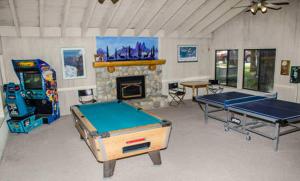 Habitación con 2 mesas de ping pong y chimenea. en Sunshine Village #142 Close to Shops & Eats, en Mammoth Lakes