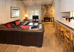 Una sala de estar con un sofá de cuero marrón y una chimenea. en Sunshine Village #142 Close to Shops & Eats, en Mammoth Lakes