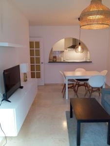 a living room with a tv and a table at Capitán - 2 habitaciones centro de Fuengirola in Fuengirola +17 photos