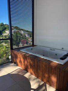 a bath tub in a room with a large window at Céu do Morro in Morro de São Paulo