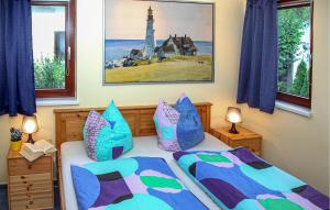 a bedroom with two beds with blue and purple pillows at Amazing Home In Rechlin With Wifi in Zielow