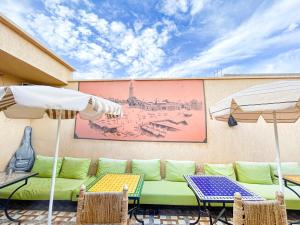 a patio with a couch and tables and umbrellas at Sun Hostel in Marrakesh