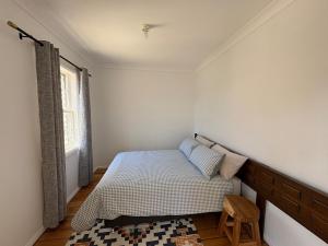 a small bedroom with a bed and a chair at The Hidden Nook in Armidale