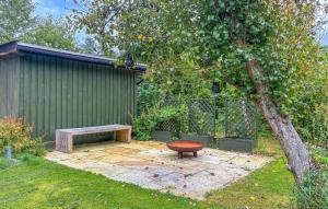 a bench sitting in a yard next to a tree at 2 Bedroom Gorgeous Home In Græsted in Græsted