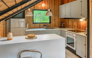 a kitchen with white appliances and wooden walls at 2 Bedroom Gorgeous Home In Græsted in Græsted