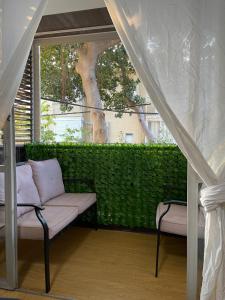a porch with a couch and a window at Bat Galim BEACH- Mirror apartment in Haifa