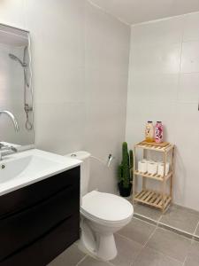 a white bathroom with a toilet and a sink at Bat Galim BEACH- Mirror apartment in Haifa +16 photos