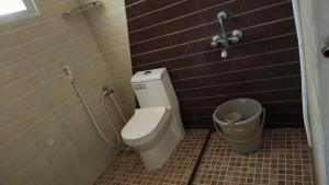 a bathroom with a toilet and a trash can at Pks Grand Park in Coimbatore
