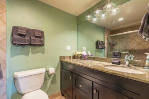 a bathroom with a toilet and a sink and a mirror at Kona Plaza#409 in Kailua-Kona +21 photos