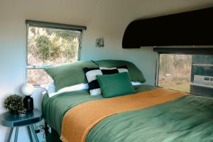 a bedroom with a bed and a window at Airstream Caravan at Matakana Retreat in Matakana