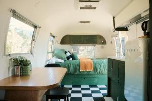 a kitchen and a bedroom in a tiny house at Airstream Caravan at Matakana Retreat in Matakana