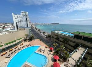 a view of a swimming pool and the beach at Barceló Colon Miramar Salinas suite in Salinas