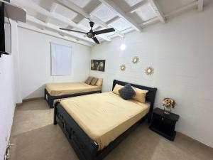 une chambre avec deux lits et un ventilateur de plafond dans l'établissement Happy tours apartments, à Carthagène des Indes 82 autres photos